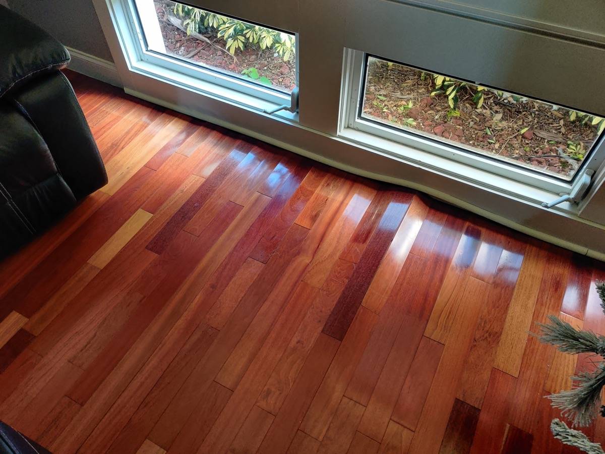 Cupped prefinished hardwood flooring near exterior wall — moisture damage from wall leak in Orlando FL